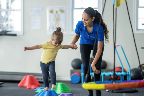 Allied Health Assistant guiding a child through an obstacle course during therapy in Kiama Downs, building confidence, coordination, and motor planning skills.