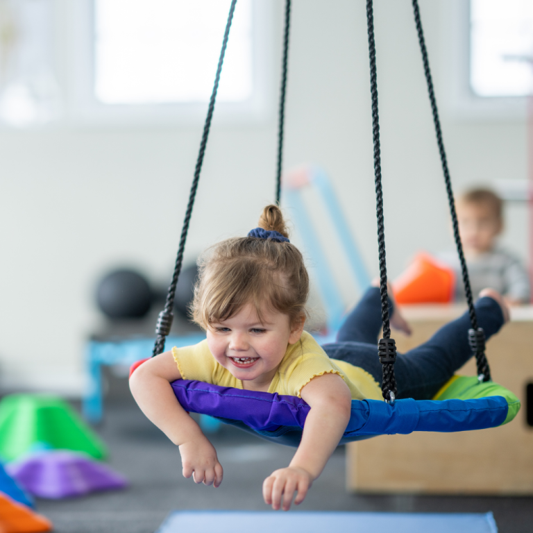 Child lying prone on a therapy swing during occupational therapy in Kiama Downs, supporting sensory regulation, vestibular function and motor skills with Koru Allied Therapies.