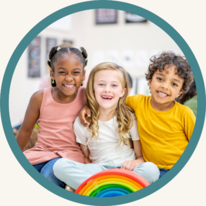 Three smiling children sitting together in a clinic setting holding a rainbow toy, representing the welcoming and inclusive environment of the Handwriting Helpers program